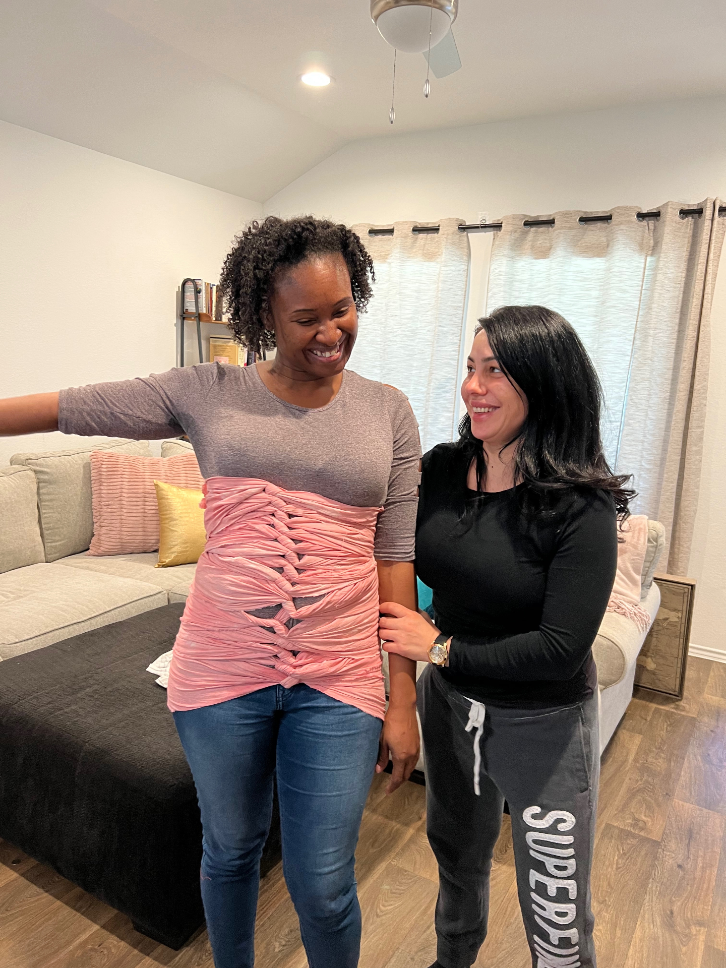Gaya demonstrating a postpartum belly bind with a new mother