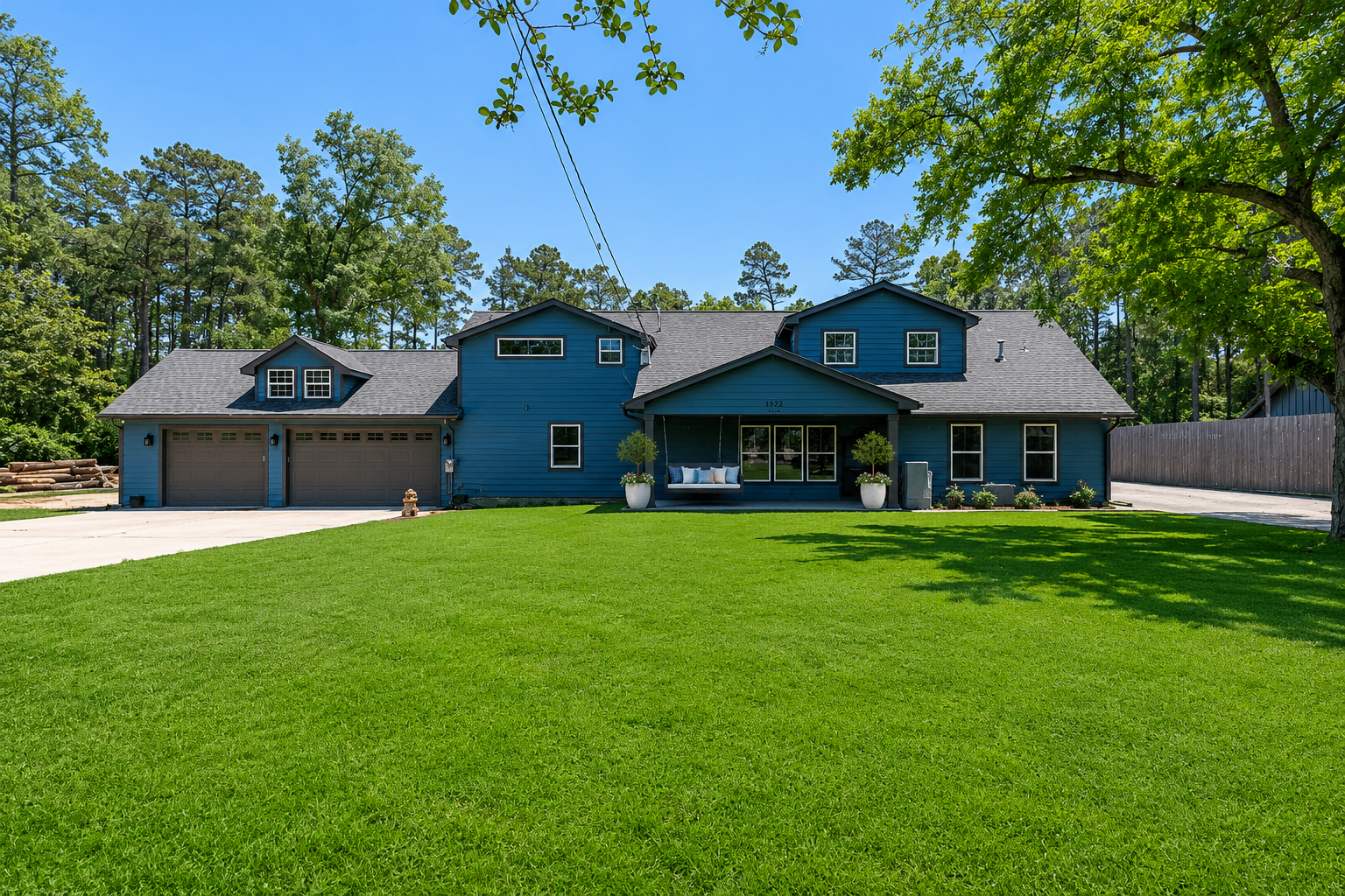 The house, set back from the road, green lawn, big trees