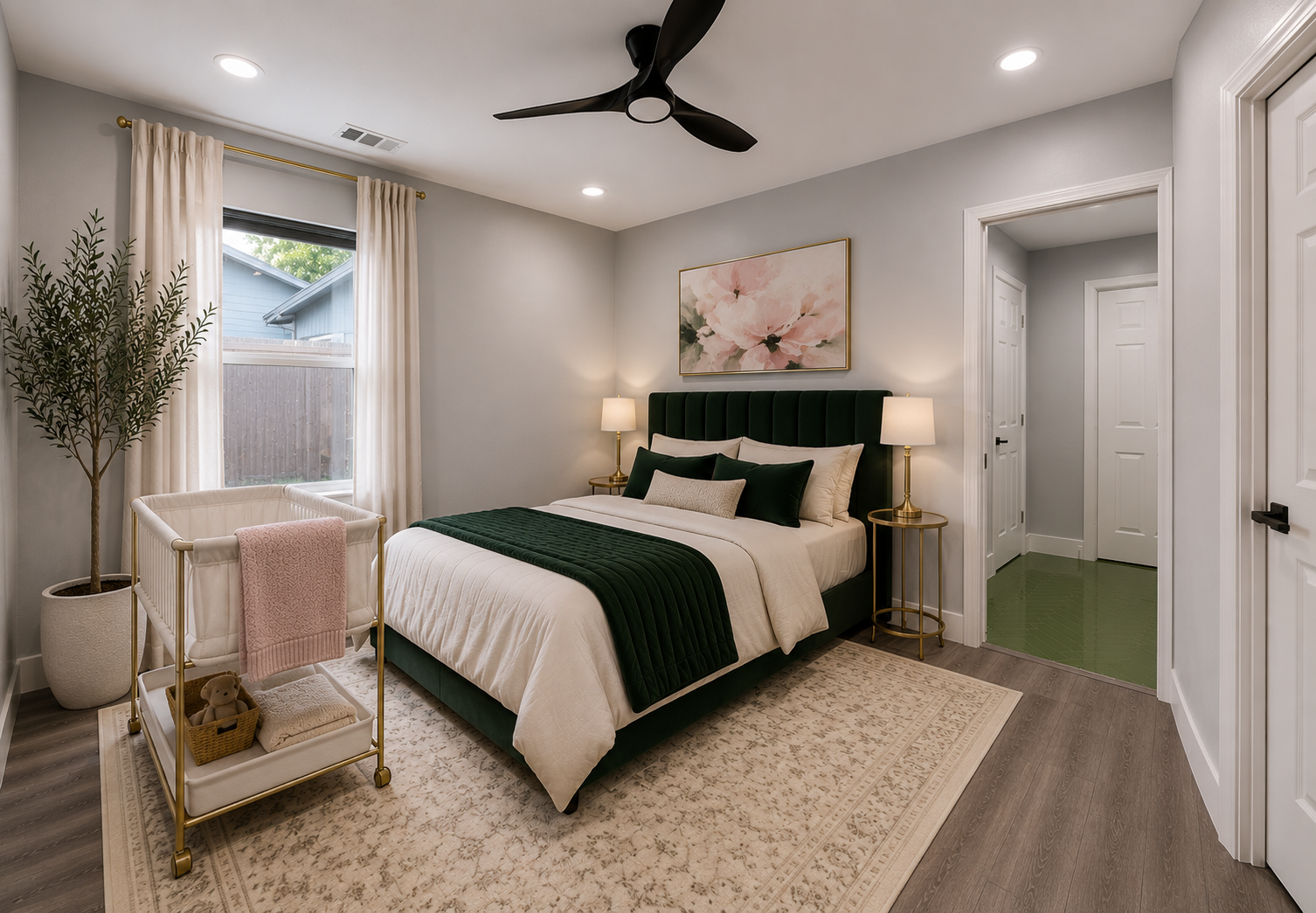 A serene downstairs suite, deep green velvet bed, bassinet beside it, soft natural light